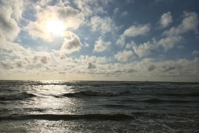 Das Meer mit Sonne hinter den Wolken