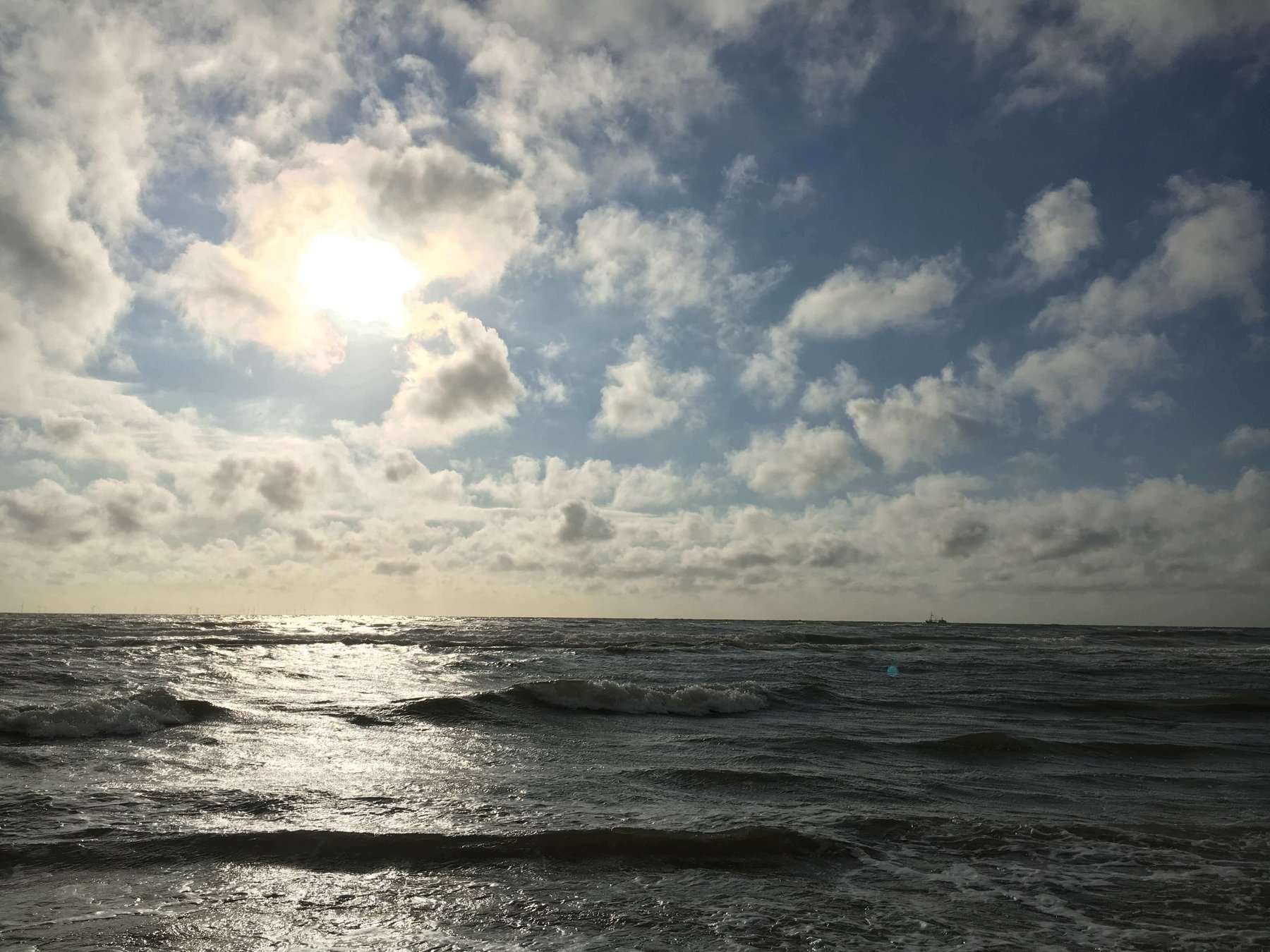 Das Meer mit Sonne hinter den Wolken