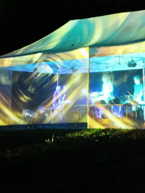 Konzert - Ein beleuchtetes Zelt in dem die Band spielt