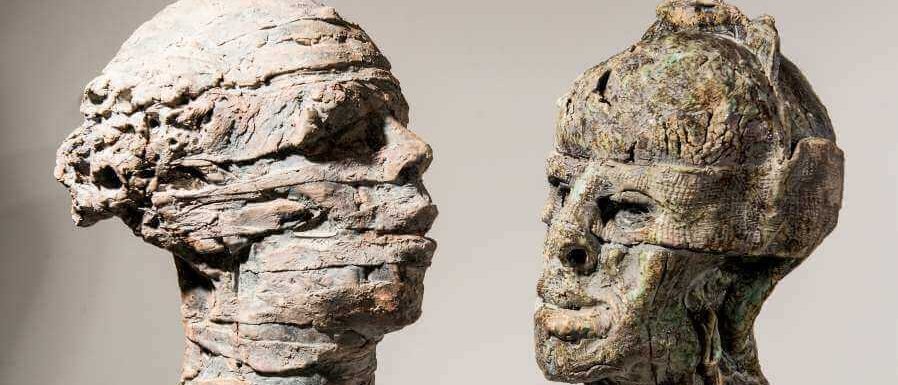 Bild zweier surrealer Kopfskulpturen aus Ton von Kuno Lange