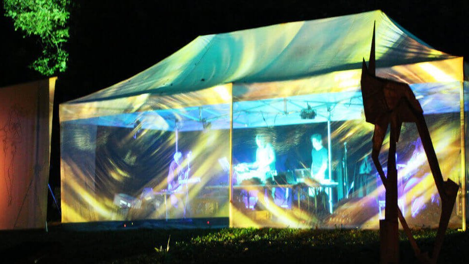 Konzert - Ein beleuchtetes Zelt in dem die Band spielt