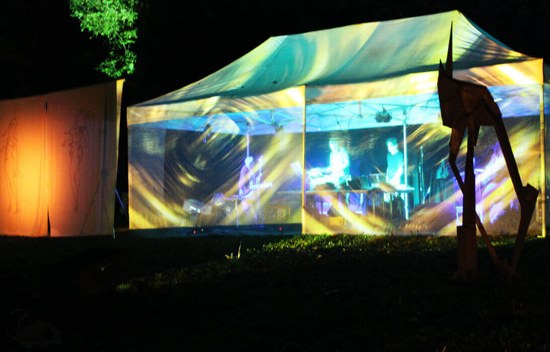 Konzert - Ein beleuchtetes Zelt in dem die Band spielt